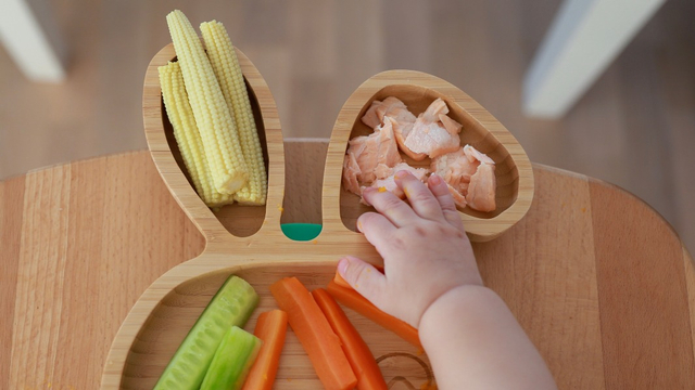 Ilustrasi bayi meraih irisan daging ikan salmon yang sudah dimasak. Foto: Shutterstock