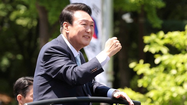 Presiden baru Korea Selatan Yoon Suk-yeol melambai kepada para pendukungnya saat pergi setelah menghadiri upacara pelantikannya di Majelis Nasional di Seoul, Korea Selatan, Selasa (10/5/2022). Foto: Yonhap via REUTERS