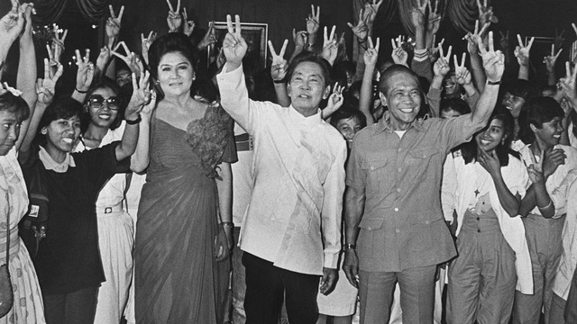 Presiden Filipina Ferdinand Marcos (tengah), istrinya Imelda dan Wakil Presidennya Arturo Tolentino membuat tanda "V" untuk kemenangan pemilihan presiden, 16 Februari 1986 di Manila di Istana Malacanang. Foto: HO/AFP