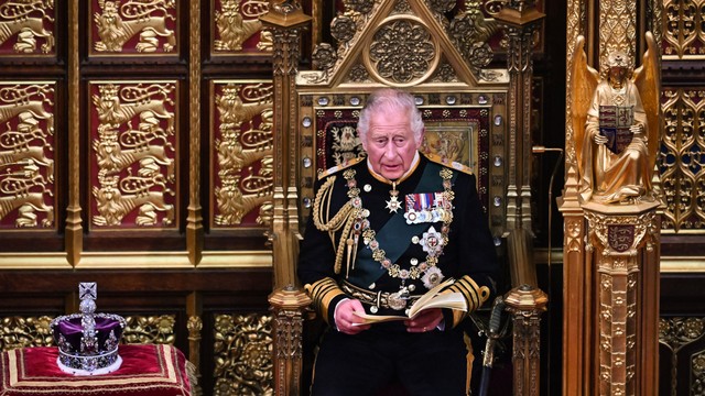 Pengeran Charles membacakan Pidato Ratu saat ia duduk di dekat Mahkota Negara Kekaisaran, selama Pembukaan Parlemen Negara di Gedung Parlemen, di London, Inggris, Selasa (10/5/2022). Foto: BEN STANSALL/AFP/POOL
