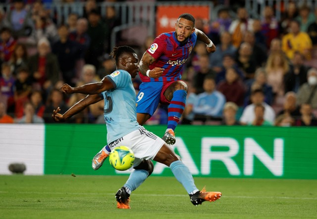 Joseph Aidoo dari Celta Vigo duel dengan Memphis Depay dari FC Barcelona saat pertandingan LaLiga di Camp Nou, Barcelona, Spanyol. Foto: Albert Gea/Reuters