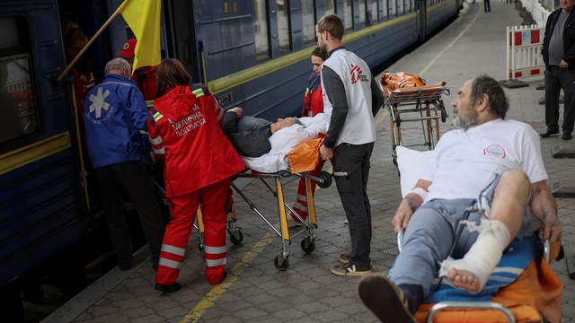 Petugas medis membawa pasien korban invasi Rusia di Ukraina Timur ke daerah Dnipro, Selasa (10/5/2022). Foto: Gleb Garanich/Reuters