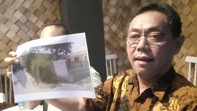 Pengacara pemilik lahan, Bambang Ary Wibowo, menunjukkan foto bagian tembok bekas Keraton Kartasura yang berubah menjadi tembok rumah warga. FOTO: Agung Santoso 