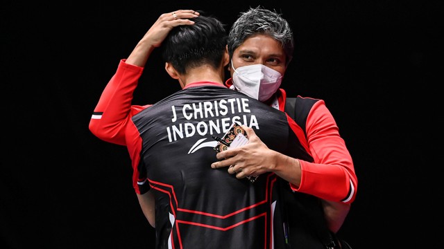 Pebulu tangkis tunggal putra Indonesia Jonatan Christie berpelukan dengan pelatihnya Irwansyah usai mengalahkan pebulu tangkis tunggal putra Cina Li Shi Feng dalam babak perempat final Piala Thomas 2022. Foto: M Risyal Hidayat/Antara Foto 