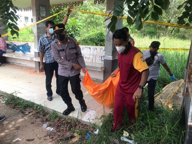 Petugas mengevakuasi jasad Erman yang ditemukan tak bernyawa di halte SMP Negeri 12 Tanjungpinang. (Foto: ist/batamnews)
