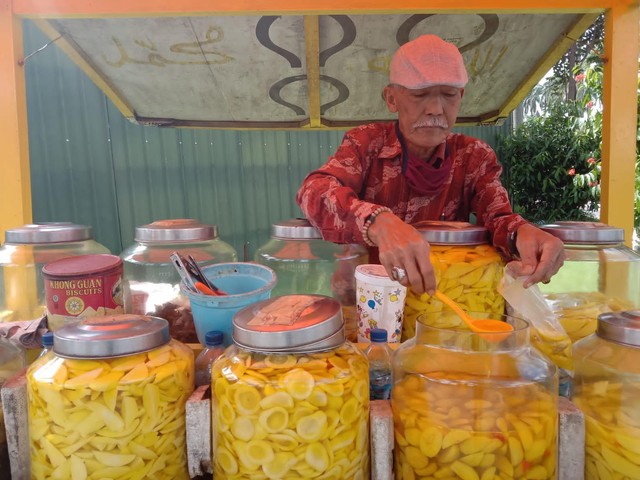 Hadi Sutejo menjajakan kuliner manisan buah warisan nenek moyangnya di Jalan Besar Dempo Kota Malang. Foto: M Sholeh