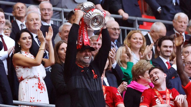 Manajer Liverpool Juergen Klopp mengangkat trofi setelah memenangkan final Piala FA di Stadion Wembley, London, Inggris, Sabtu (14/5/2022). Foto: Action Images via Reuters/Peter Cziborra