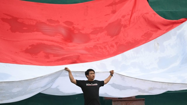 Suporter Indonesia mengibarkan bendera merah putih ketika Timnas Indonesia melawan Timnas Myanmar dalam laga lanjutan Grup A Sepak Bola SEA Games 2021 Vietnam di Stadion Viet Tri, Phu Tho, Vietnam, Minggu (15/5/2022). Foto: Zabur Karuru/ANTARA FOTO