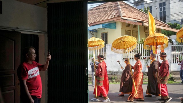 Seorang warga yang tengah mengabadikan momen prosesi pradaksina atau mengelilngi tempat suci yang menjadi rangkaian perayaan waisak di wihara dharmakirti di Palembang, Senin (16/5) Foto: abp/Urban Id