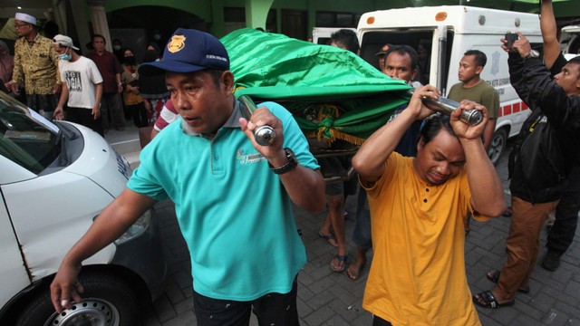 Warga mengangkat jenazah korban kecelakaan bus pariwisata untuk dimakamkan di Makam Islam Benowo, Surabaya, Jawa Timur, Senin (16/5/2022). Foto: Didik Suhartono/Antara Foto