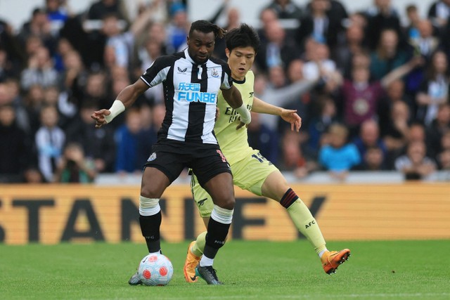 Pemain Arsenal Takehiro Tomiyasu berebut bola dengan pemain Newcastle United Allan Saint-Maximin pada pertandingan lanjutan Liga Inggris di Stadion St James' Park, Newcastle, Inggris. Foto: Lee Smith/REUTERS