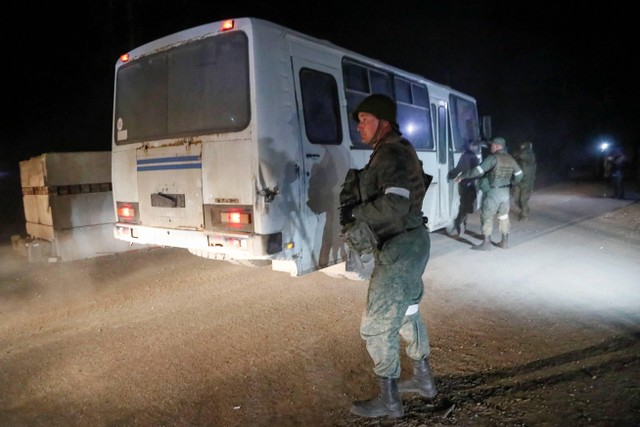 Para tentara mengawal bus yang melakukan evakuasi di pabrik baja Avosztal, Mariupol, Ukraina, Senin (16/5/2022). Foto: Alexander Ermochenko/REUTERS