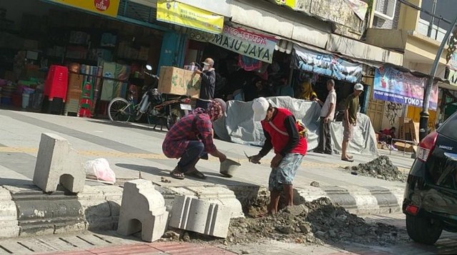 Beberapa pekerja dari DPUPR Kota Tegal mengambil alih pekerjaan setelah kontraktor penggarap City Walk Jalan Ahmad Yani, Kota Tegal diputus kontrak sejak 8 April lalu karena pekerjaan yang molor tak rampung sesuai target, Selasa (17/5/2022).