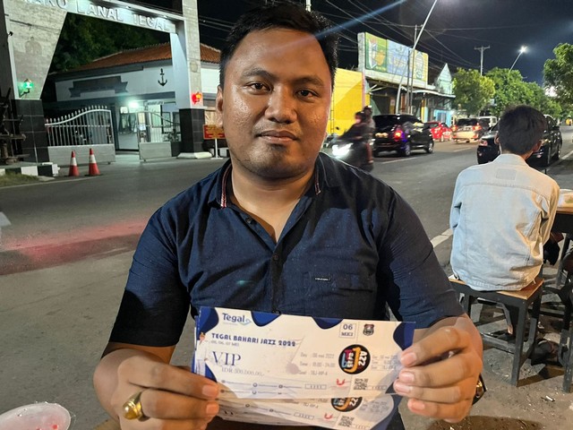 Hendra Saputra (29) warga Desa Setu, Kecamatan Tarub, Kabupaten Tegal menunjukan tiket konser Tegal Bahari Jazz yang sudah dibelinya namun acara batal digelar di Objek Wisata PAI Kota Tegal 5-7 Mei 2022 lalu, Rabu (18/5/2022) malam.