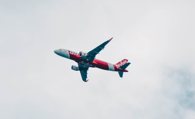 tiket pesawat Air Asia untuk rute Jakarta-Bali bulan Mei 2022. unsplash/pesawat merah dan putih