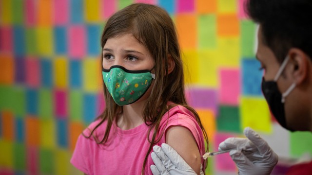 Seorang anak perempuan menerima vaksin COVID-19 Pfizer-BioNTech di Skippack Pharmacy di Schwenksville, Pennsylvania, Amerika Serikat, Kamis (19/5/2022). Foto: Hannah Beier/REUTERS