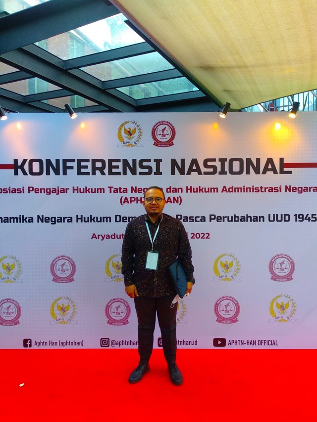 Zahlul Pasha Karim, Dosen UIN Ar-Raniry Banda Aceh, berfoto dengan latar backdrop Konferensi Nasional yang digelar APHTN-HAN di Bali. Foto: Dok. Pribadi
