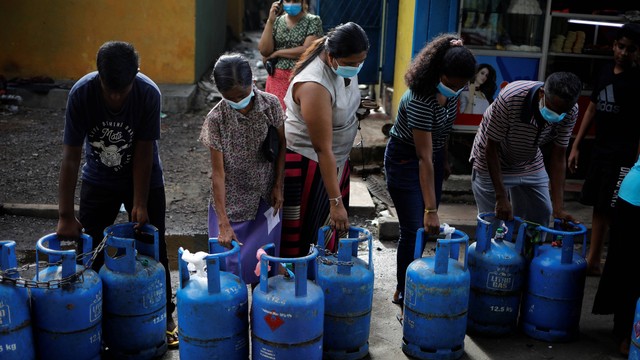 Warga membawa tabung gas kosong untuk antre membeli gas domestik ke agen pusat distribusi saat krisis ekonomi di Kolombo, Sri Lanka, Jumat (20/5/2022). Foto: Adnan Abidi/REUTERS