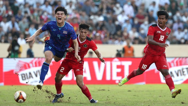 Pemain Timnas Thailand Jonathan Khemdee berusaha melewati pemain Timnas Indonesia pada pertandingan semifinal sepak bola SEA Games 2021 Vietnam di Stadion Thien Truong, Nam Dinh, Vietnam, Kamis (19/5/2022). Foto: Chalinee Thirasupa / REUTERS