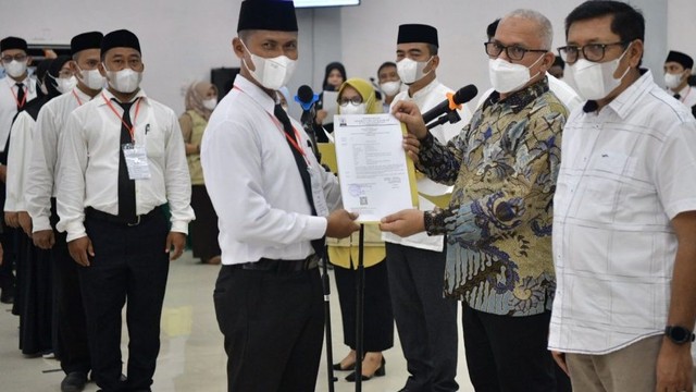 Sekda Aceh, Taqwallah, didampingi Kadisdik Aceh, Alhudri, menyerahkan secara langsung SK pengangkatan kepada guru SMA, SMK dan SLB sebagai PPPK. Foto: Adpim Setda Aceh