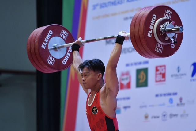 Lifter Indonesia Rahmat Erwin Abdullah melakukan angkatan pada final angkat besi nomor 73 Kg putra SEA Games 2021 Vietnam di Hanoi Sports Training and Competition Center, Hanoi, Vietnam, Sabtu (21/5/2022).  Foto: Zabur Karuru/ANTARA FOTO