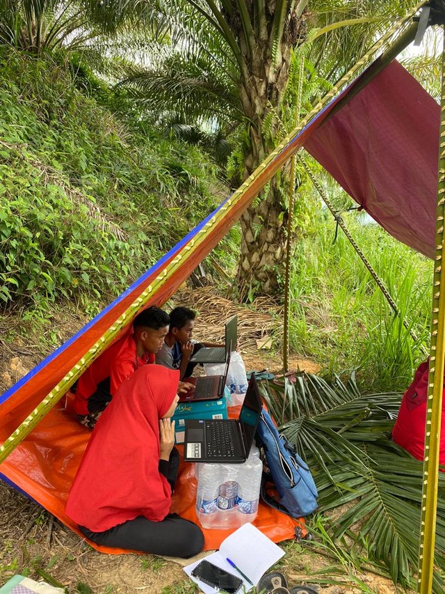 Para siswa yang terpaksa mengikuti Ujian Paket A secara online di bawah tenda, di tempat yang terdapat sinyal internet yang kuat dan stabil. Sumber: Koleksi CLC Benta Belian, Kalabakan, Sabah, Malaysia.