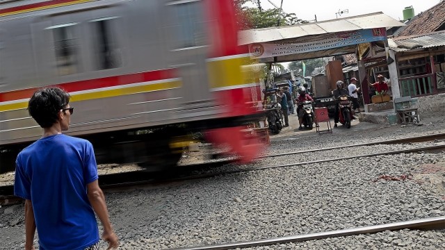 Pengendara motor melintas di perlintasan kereta api tanpa palang pintu di kawasan Petamburan. Foto: ANTARA FOTO/Galih Pradipta