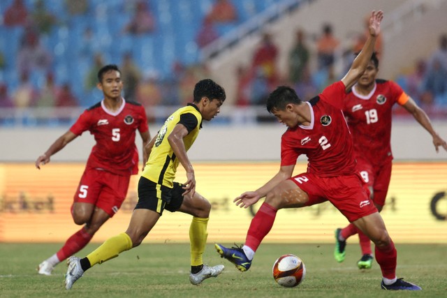 Pemain Timnas Indonesia Alfeandra Dewangga Santosa berebut bola dengan pemain Timnas Malaysia pada pertandingan perebutan medali perungu SEA Games 2021 Vietnam di Stadion Viet Tri - Viet Tri, Vietnam. Foto: Chalinee Thirasupa/REUTERS