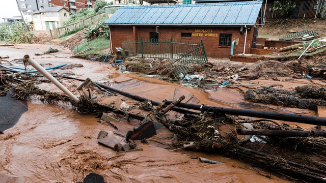 Rumah dan jalan yang rusak parah setelah hujan lebat dan angin kencang di Umdloti di utara Durban, Afrika Selatan, Minggu (22/5/2022). Foto: Rajesh Jantilal/AFP