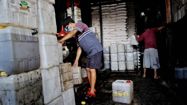 Pekerja mengangkat minyak goreng curah kemasan jirigen di Kawasan Kebayoran Lama, Jakarta Selatan, Senin (23/5/2022). Foto: Jamal Ramadhan/kumparan