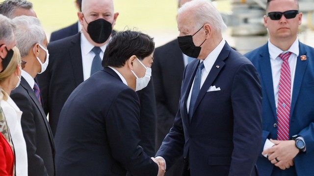 Presiden AS Joe Biden berjabat tangan dengan Menlu Jepang Yoshimasa Hayashi saat kedatangannya di Pangkalan Udara Militer AS Yokota di Fussa, Jepang, 22 Mei 2022. REUTERS/Kim Kyung-Hoon