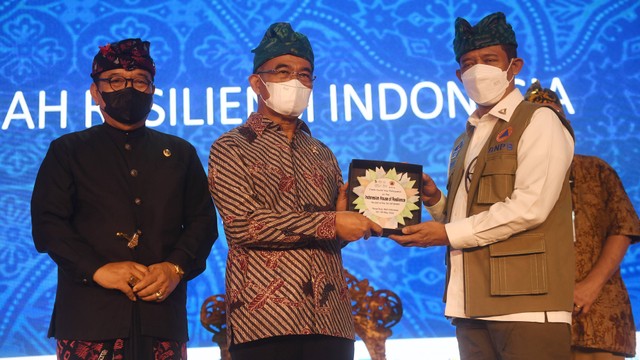 Menko PMK Muhadjir Effendy menerima cinderamata dari Ketua BNPB Letjen TNI Suharyanto (kanan) bersama Wagub Bali Tjokorda Oka Artha Ardana Sukawati (kiri) usai resmikan Rumah Resiliensi Indonesia dalam GPDRR 2022 di Nusa Dua, Bali, Senin (23/5/2022). Foto: Akbar Nugroho Gumay/ANTARA FOTO