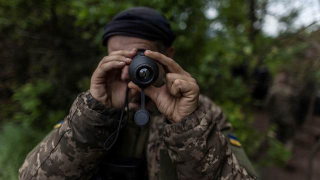 Anggota angkatan bersenjata Ukraina melakukan pengamatan area dengan teropong di dekat Donetsk, Ukraina, Minggu (22/5/2022). Foto: Carlos Barria/REUTERS