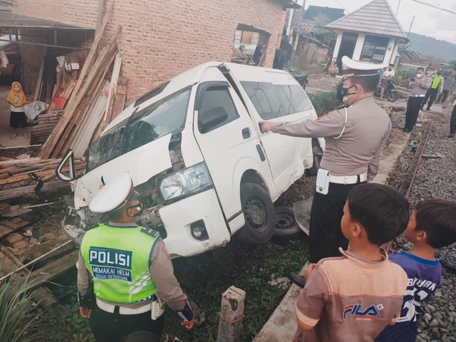 Satlantas Polresta Bandar Lampung evakuasi mobil travel merek Toyota Hiace warna putih nomor polisi F 7202 WL yang tertabrak kereta di Jalan KH Agung Anang, Ketapang, Teluk Betung Selatan. | Foto: Ist