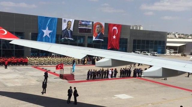 Suasana pada saat kedatangan Presiden Turki Recep Tayyip Erdogan di Mogadishu, Somalia, pada tahun 2015. Tampak di sisi bendera Turki dan Somalia terdapat potret kedua pemimpin negara: Erdogan (kanan) dan Mohamud (kiri). DAILYSABAH