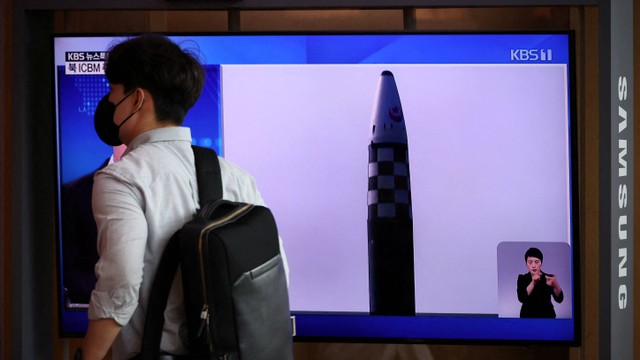 Warga melintasi siaran TV berita yang melaporkan tentang peluncuran tiga rudal Korea Utara termasuk yang dianggap sebagai rudal balistik antarbenua (ICBM), di Seoul, Korea Selatan, Rabu (25/5/2022). Foto: Kim Hong-Ji/REUTERS