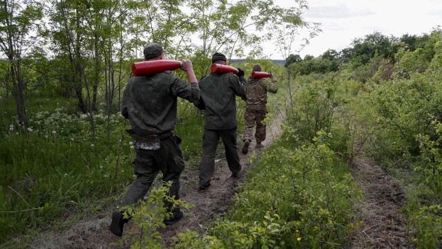 Prajurit pasukan pro-Rusia membawa selongsong peluru rudal di Luhansk, Ukraina, Selasa (24/5/2022). Foto: Alexander Ermochenko/REUTERS