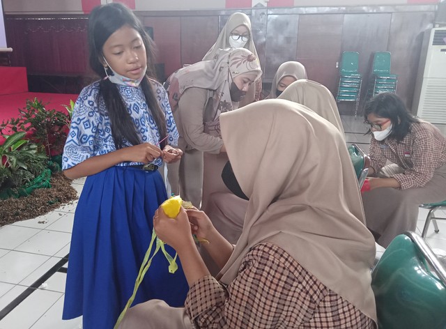 Soraya Az-Zahra Wisanggeni (baju biru) saat memberikan pelatihan mengolah kantong kresek menjadi benang rajut di SMKN 6 Surabaya, Rabu (25/5). Foto-foto: Masruroh/Basra