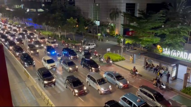 Rombongan kendaraan berorator melintasi Jalan Sudirman, Jakarta, Rabu (25/5/2022). Foto: Haya Syahira/kumparan