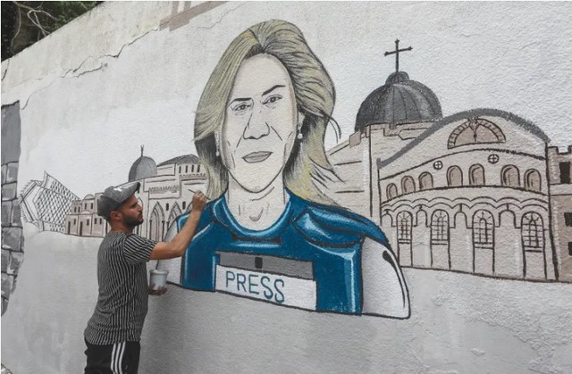 Seorang pria Palestina menggambar mural koresponden Al Jazeera Shireen Abu Akleh di Khan Yunis, Jalur Gaza.(kredit foto: ABED RAHIM KHATIB/FLASH90)
