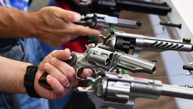 Para peserta memegang pistol revolver Ruger selama Pertemuan Tahunan National Rifle Association (NRA) di George R. Brown Convention Center, di Houston, Texas, Amerika Serikat pada Sabtu (28/5/2022). Foto: Patrick T. Fallon/AFP