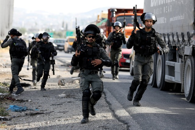 Petugas polisi perbatasan berlari selama protes atas ketegangan di Masjid Al-Aqsa Yerusalem, di pos pemeriksaan Huwara, dekat Nablus di Tepi Barat. Foto: Raneen Sawafta/ REUTERS