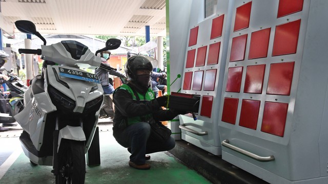 Pengemudi ojek daring mengganti baterai sepeda motor listriknya di stasiun pengisian baterai listrik di Kuningan, Jakarta, Senin (30/5/2022). Foto: Aditya Pradana Putra/ANTARA FOTO