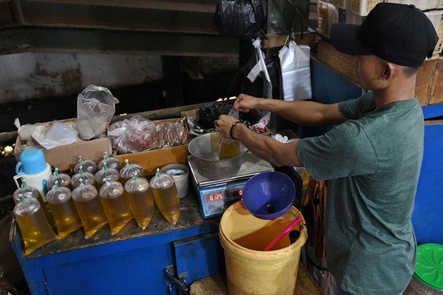 Pedagang menimbang minyak goreng curah yang dikemas di dalam kantong plastik di Pasar Senen, Jakarta, Selasa (31/5/2022). Foto: Aditya Pradana Putra/ANTARA FOTO