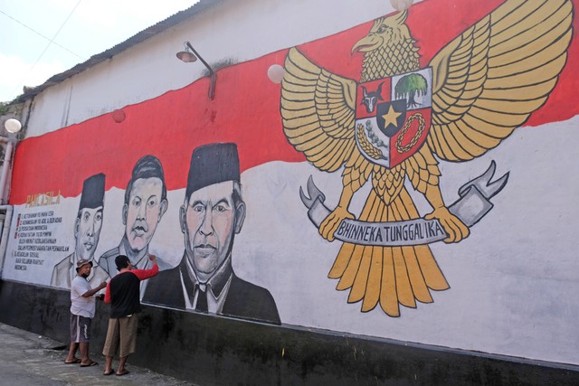 Warga menyelesaikan pembuatan mural bertema Pancasila di kampung Pancasila Desa Karangwatu, Muntilan, Magelang, Jawa Tengah, Selasa (31/5/2022). Foto: Anis Efizudin/ANTARA FOTO