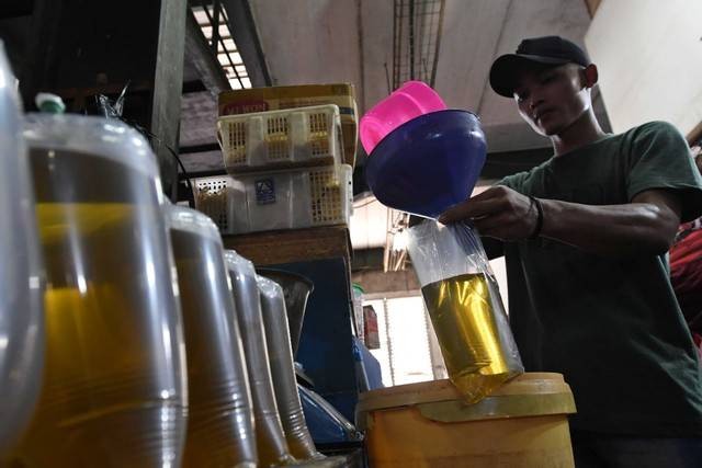 Pedagang menimbang minyak goreng curah yang dikemas di dalam kantong plastik di Pasar Senen, Jakarta, Selasa (31/5/2022). Foto: Aditya Pradana Putra/ANTARA FOTO