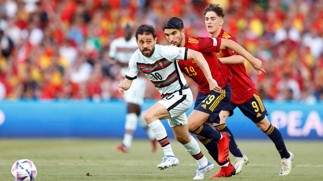 Pemain Portugal Bernardo Silva beraksi dengan pemain Spanyol Carlos Soler di Estadio Benito Villamarin, Seville, Spanyol, Kamis (2/6/2022). Foto: Marcelo Del Pozo/REUTERS