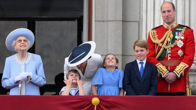 Kate Middleton berbicara dengan Pangeran Louis dari Cambridge (kedua dari kiri) saat mereka berdiri dengan Ratu Inggris Elizabeth II (kiri), Putri Charlotte, Pangeran George dan Pangeran William saat menonton flypast khusus dari balkon Istana. Foto: Daniel Leal / AFP