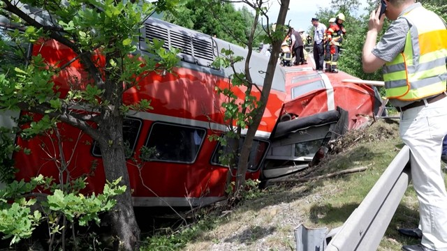 Pemadam kebakaran dan penyelamat bekerja di gerbong kereta yang terbalik di dekat Burgrain, dekat Garmisch-Partenkirchen, Jerman selatan, Jumat (4/6/2022). Foto: NETWORK PICTURES/AFP