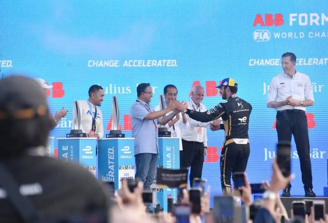 Presiden Jokowi dan Gubernur Anies Baswedan menyerahkan piala kepada juara pertama, Mitch Evans,  tim Jaguar TCS Racing menjadi yang tercepat di Formula E Jakarta, Sabtu (4/6/2022). Foto: Instagram/@aniesbaswedan